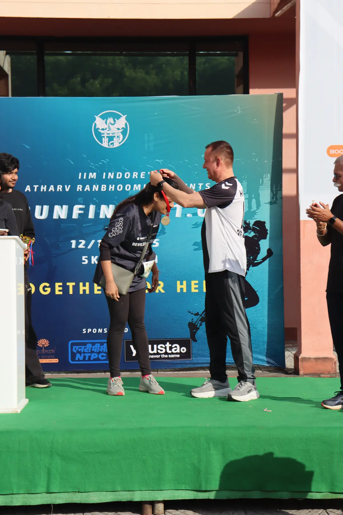 A finisher receiving her medal on the Runfinity 1.0 stage